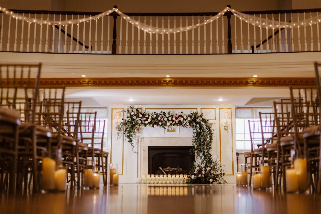 Indoor ceremony with fireplace candles and florals at The Commons 1854