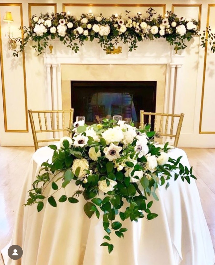 Sweetheart table with white floral arrangement at The Commons 1854