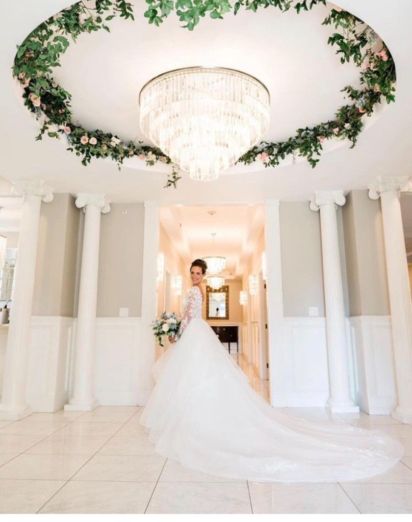 Bride under Swarovski chandelier in the rotunda