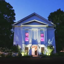 The Commons 1854 at twilight with purple uplighting
